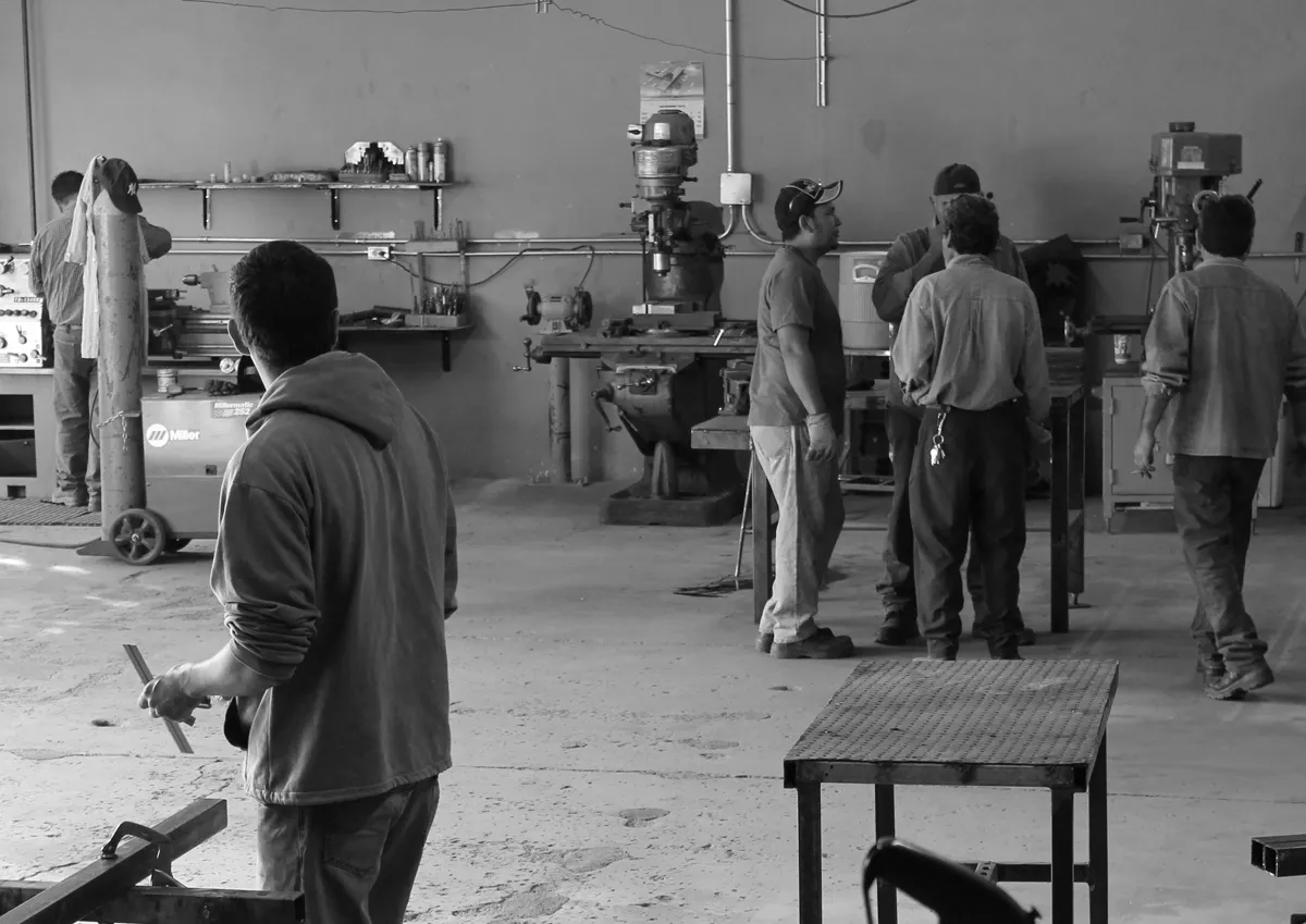 Equipo de técnicos en el taller de ACI, junto a máquinas y una fresadora