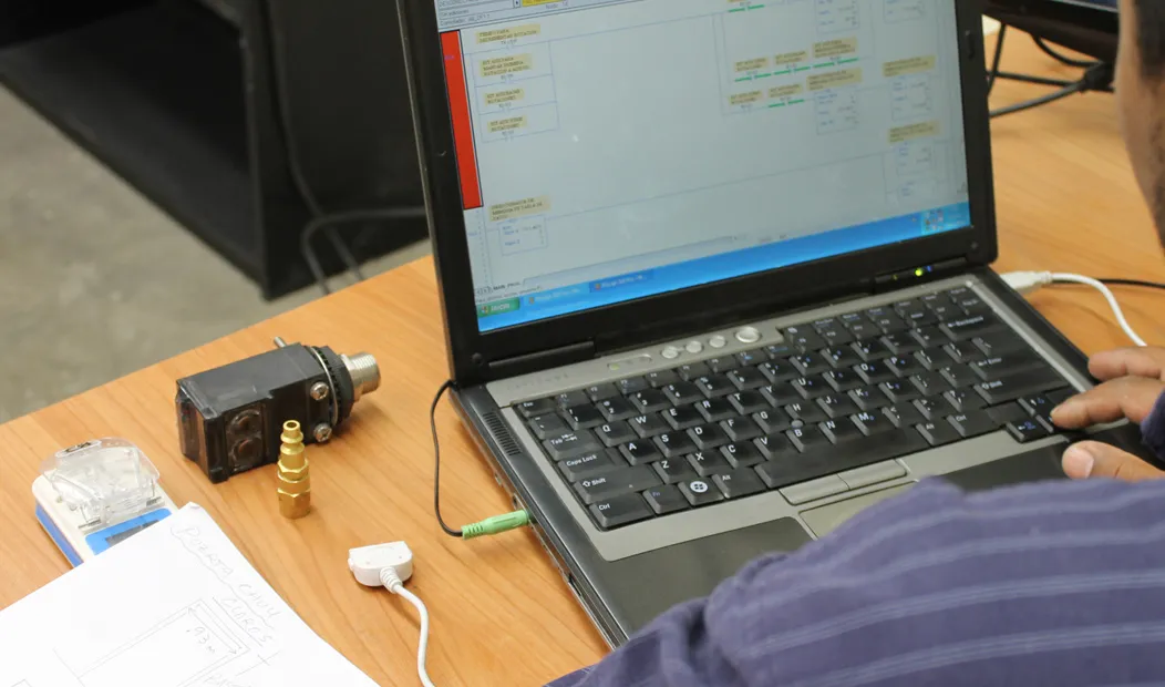 Laptop de programación conectada por cable a un equipo